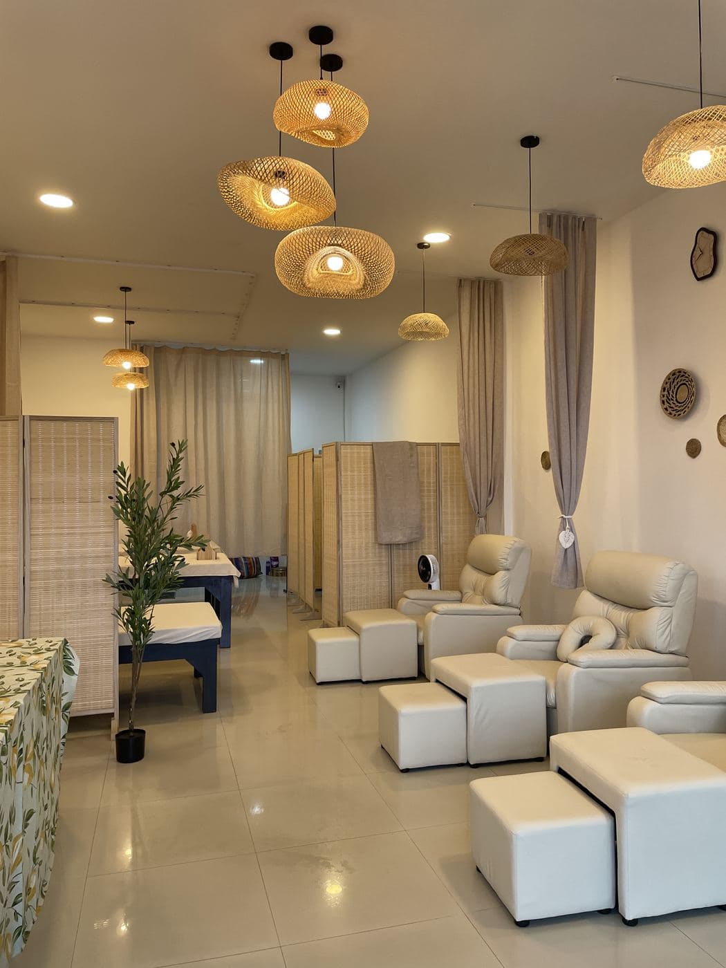 The SabaiSen lounge in the evening: rattan lamps, foot massage recliners and massage tables